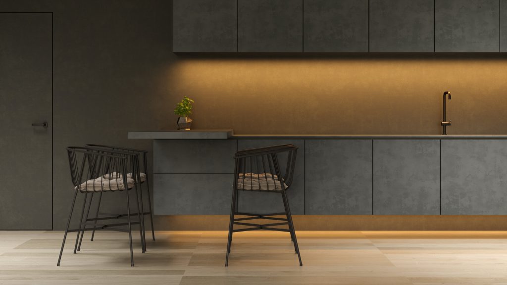 A dark gray kitchen run lit from under the cabinets, with two wire bar stools at the counter
