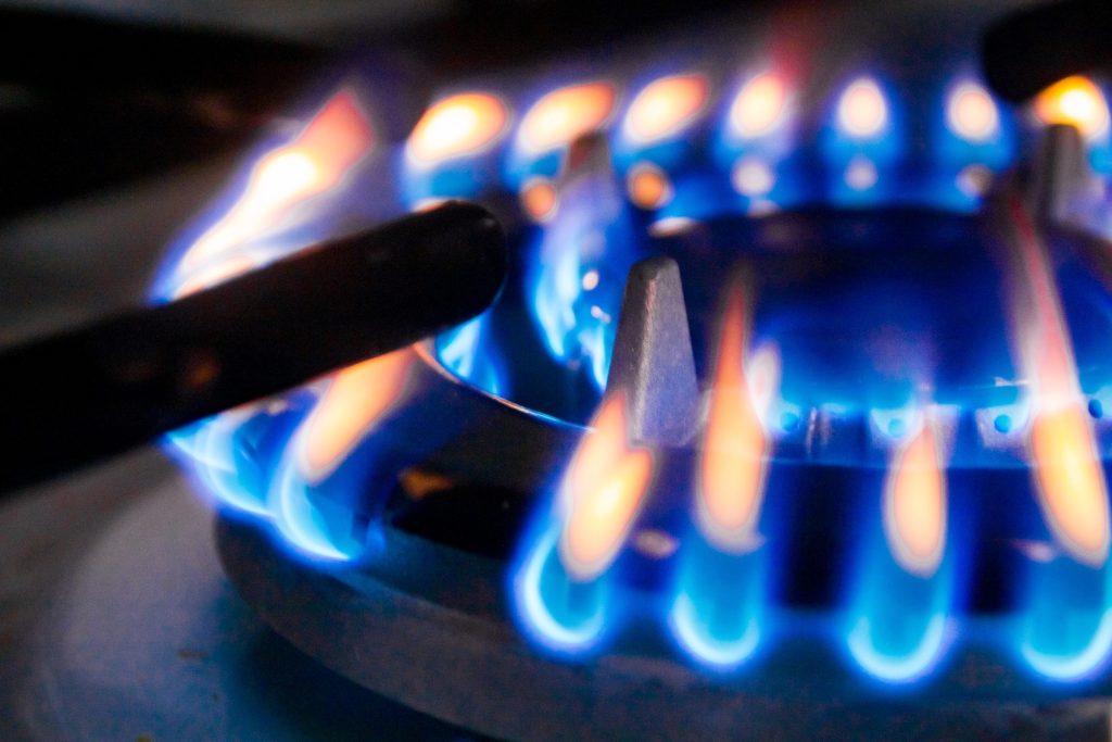 A gas burner alight with mixed blue and orange flames.
