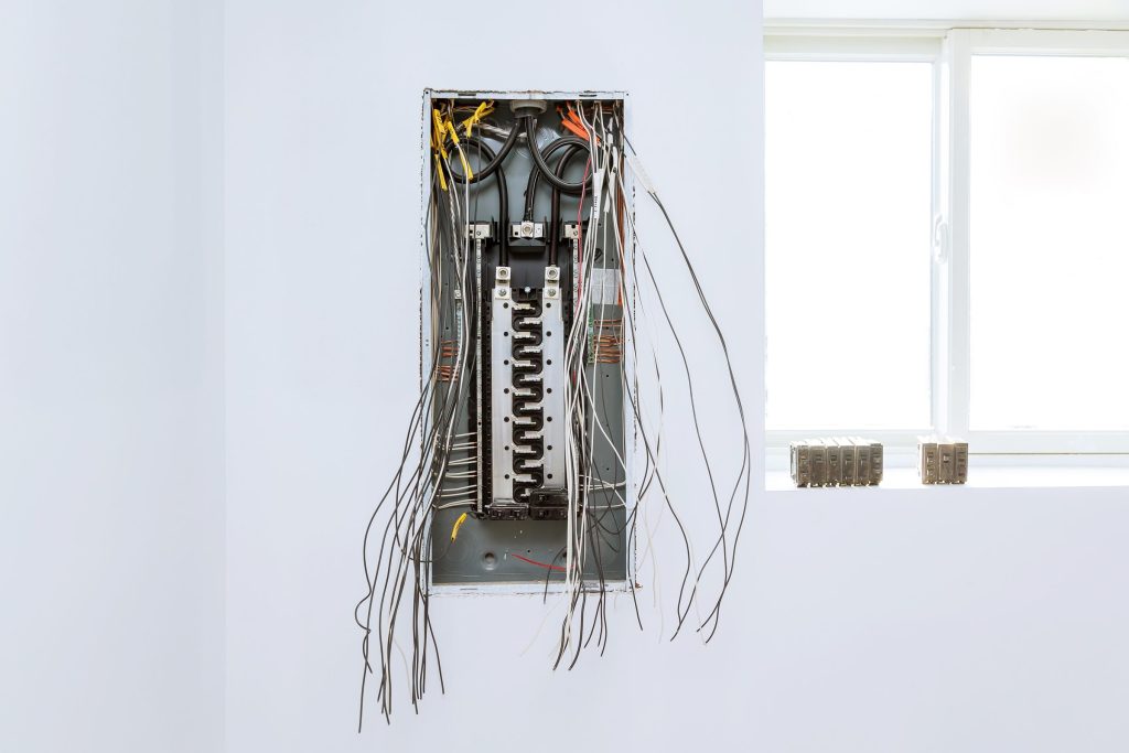 An open household breaker panel with its circuits and wiring exposed.