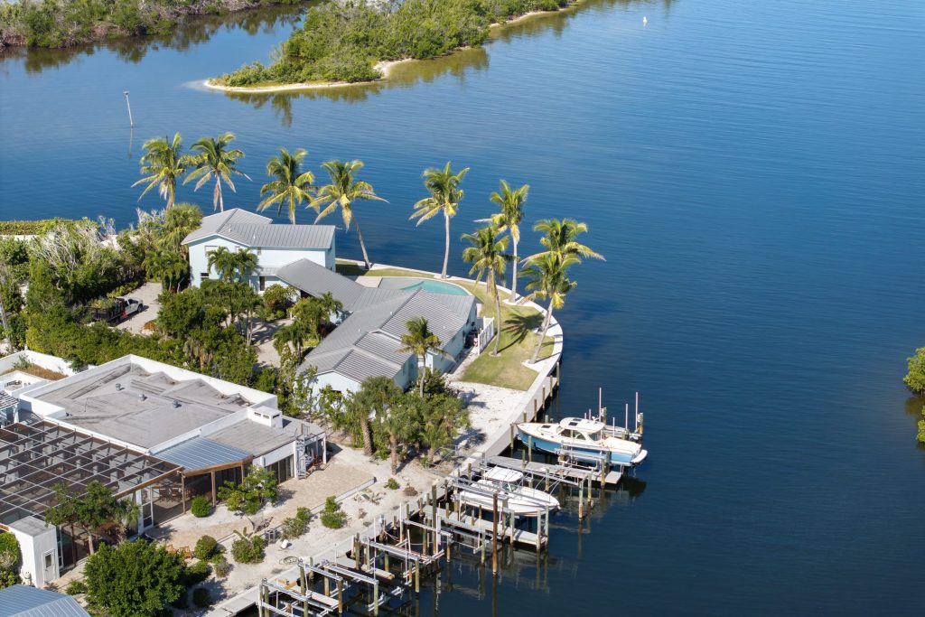 Waterfront houses with private docks and boat lifts on a point, from the air