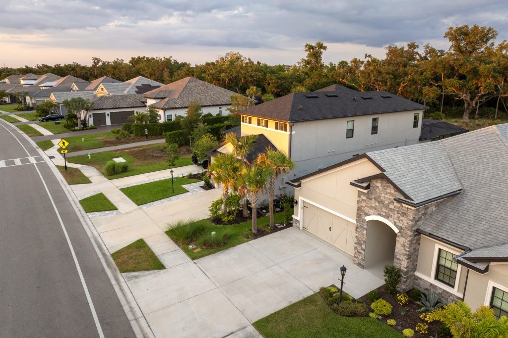 New houses with stone porches along a curving street, from above
