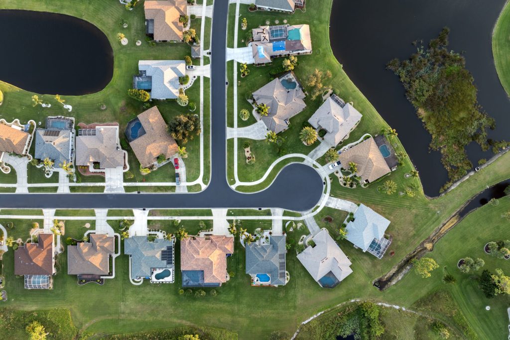 Rows of houses with pools and gardens seen straight down from the air