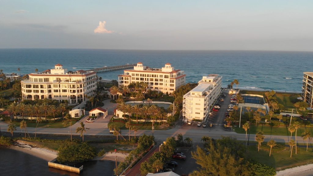 Low buildings and a pier along the shore in late afternoon light