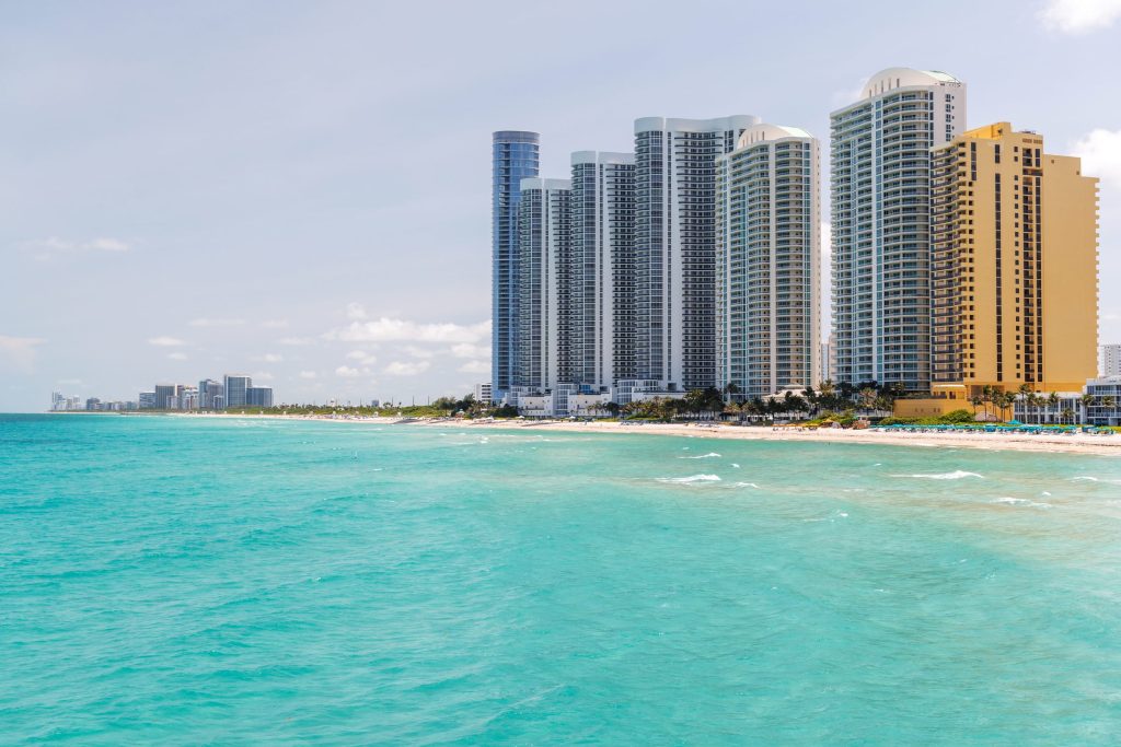 Condo towers standing over a beach and turquoise shallows