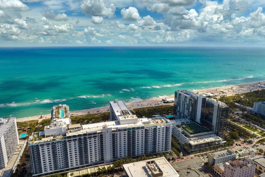 Wide sand and turquoise water with low blocks along the shore