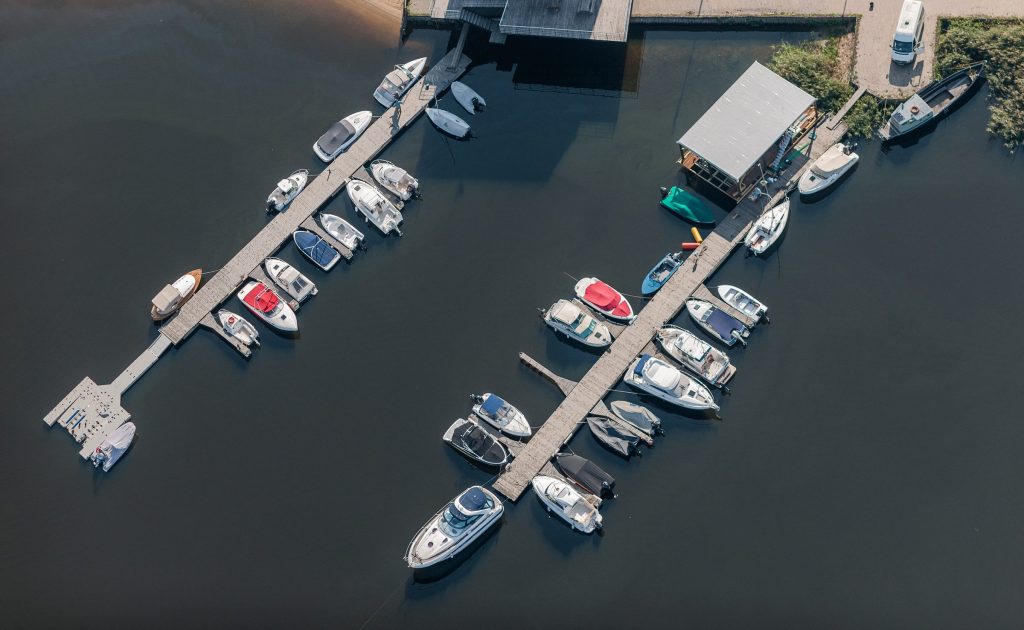 A marina of moored boats along two piers, straight down from the air