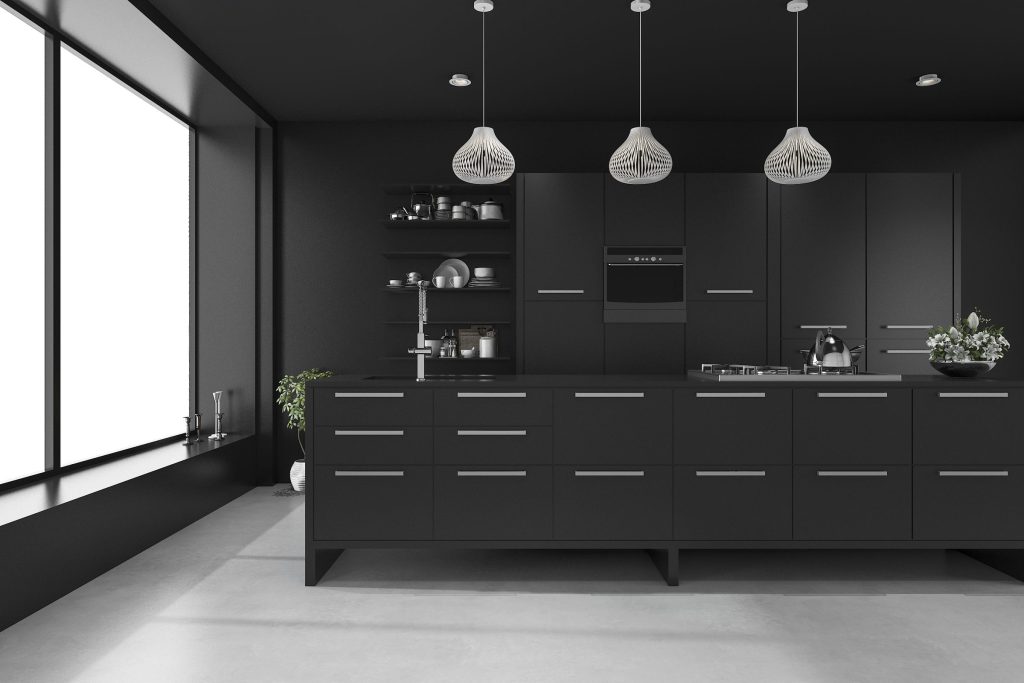 A black galley kitchen with three pendant lights and a tall window at the end.