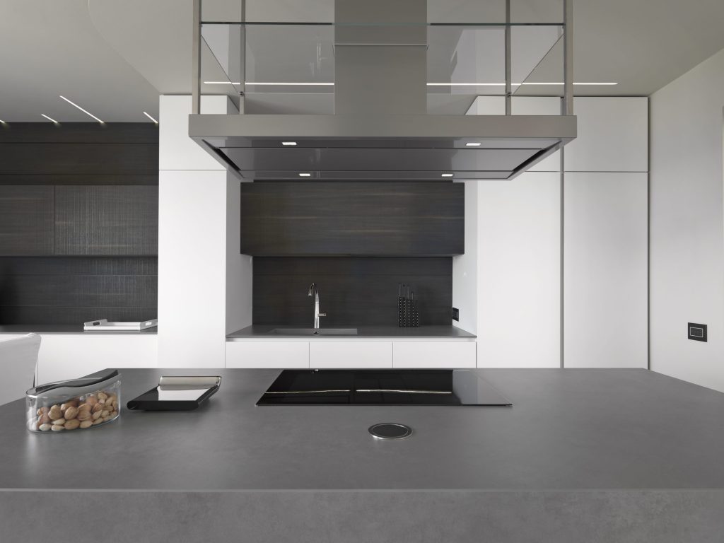 A minimal grey kitchen with an island hood over a flush induction hob