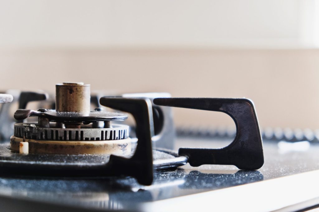A gas burner with its cap lifted off, the spreader and igniter electrode exposed