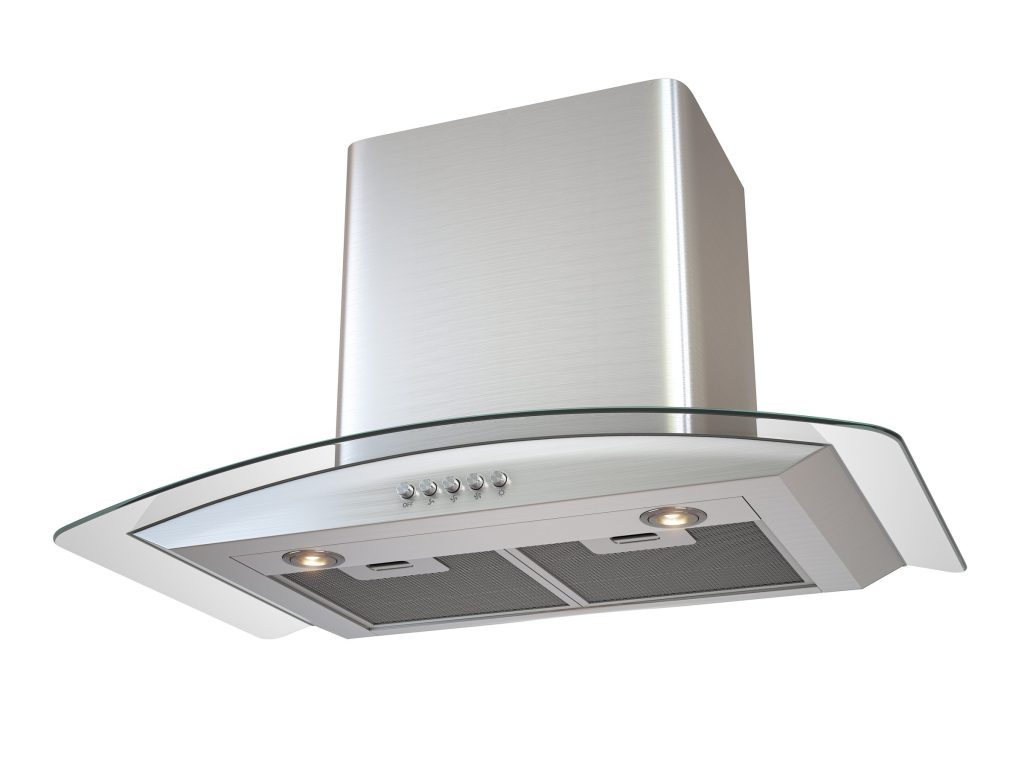 A stainless range hood with a glass visor, both of its lamps lit above the filters