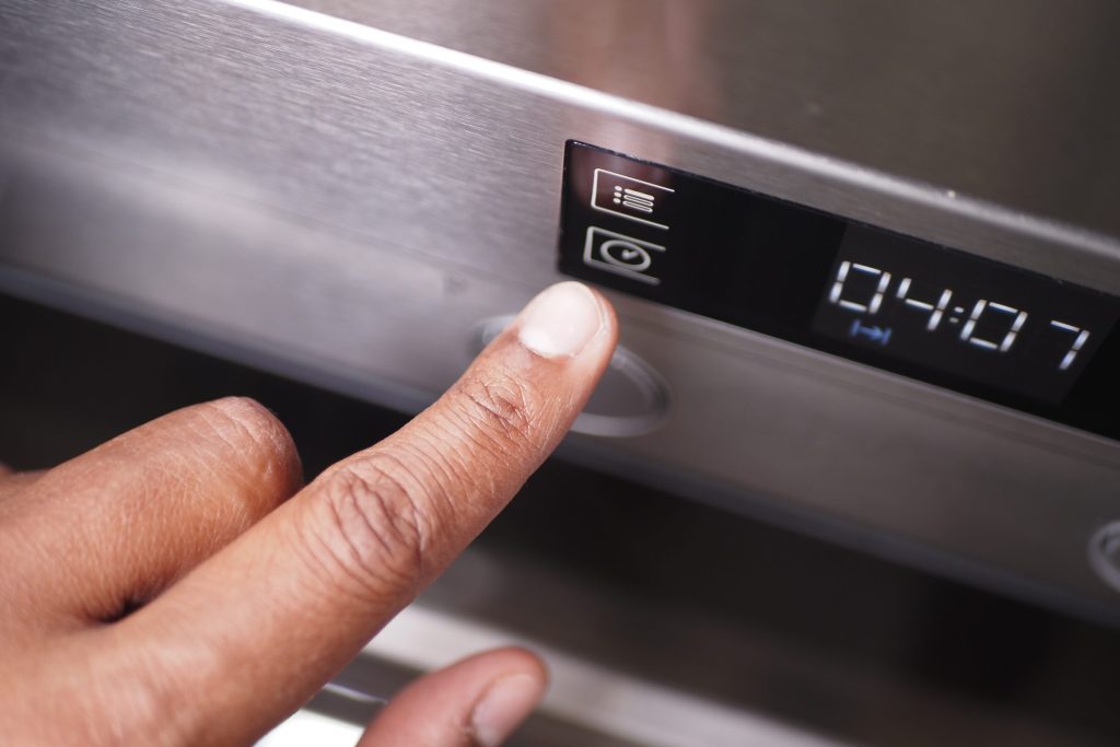 A finger pressing a touch control beside a segment display counting down